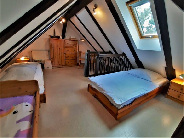 20220625_162958 (2) – Hubertus Boltenhagen Gemütliches Dachzimmer mit zwei Einzelbetten, Holzmöbeln und Dachfenster.