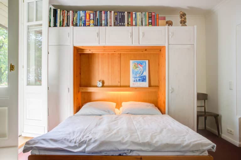 Haus_Hubertus_-32 – Hubertus Boltenhagen Doppelbett mit umgebenden weißen Schränken und Bücherregal darüber.