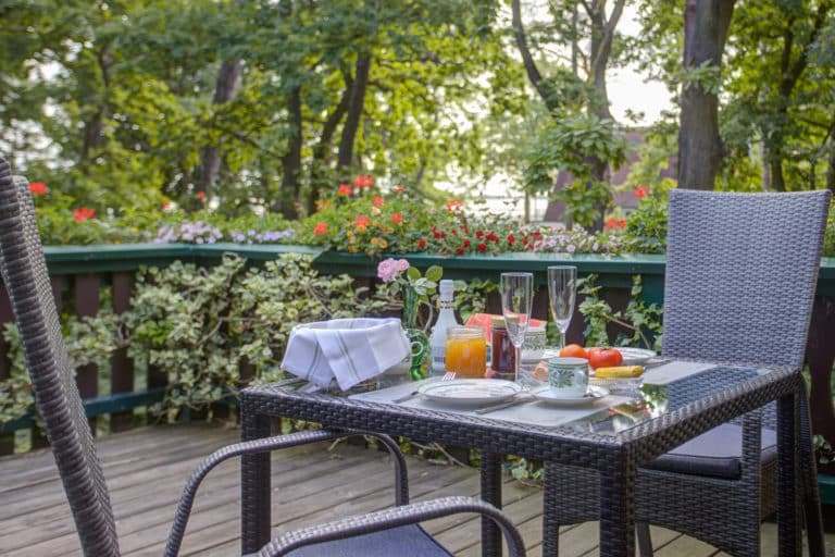 Haus_Hubertus_-7-15 – Hubertus Boltenhagen Frühstückstisch auf einer Terrasse im Grünen mit Blumen und Saft.