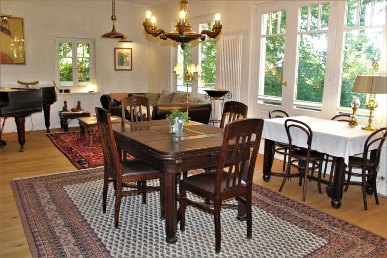 IMG_5393 (2) – Hubertus Boltenhagen Esszimmer im Vintage-Stil mit Holztisch, Teppich und Kronleuchter.