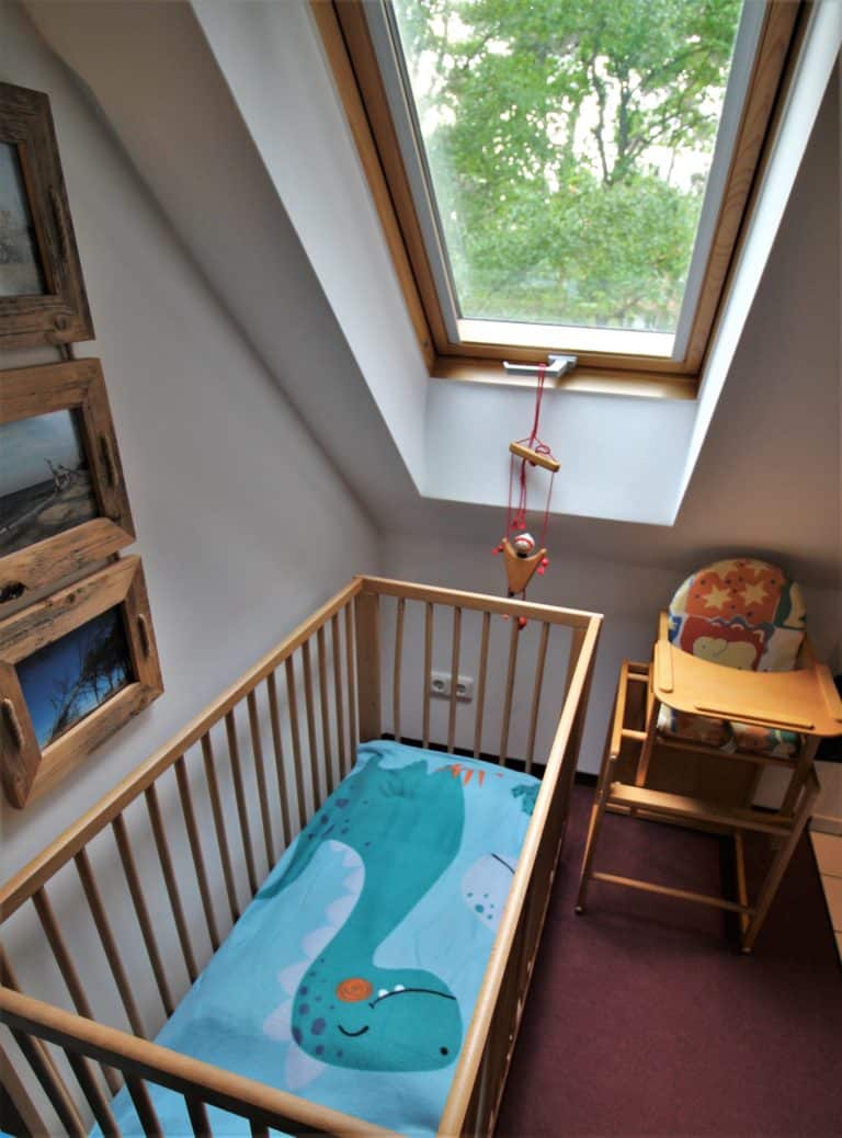 IMG_6121 (2) – Hubertus Boltenhagen Kinderzimmer mit Holzbabybett, Hochstuhl und Dachfenster.
