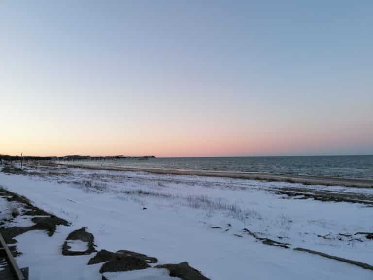 IMG_20210212_172558 – Hubertus Boltenhagen Snow-covered coastline at sunset, calm sea, clear sky.