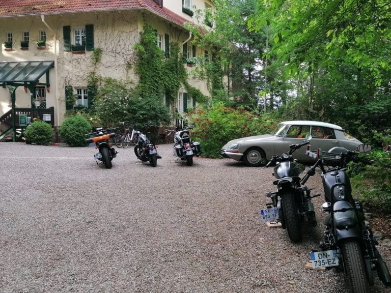 IMG-20220614-WA0014 (2) – Hubertus Boltenhagen Several motorcycles and a vintage car in front of an ivy-covered house.