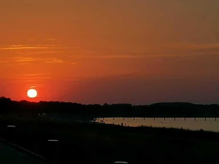 IMG-20220721-WA0003 – Hubertus Boltenhagen Sunset over calm water with an orange-red sky.