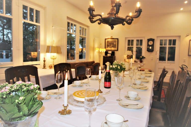 IMG_5597 (2) – Hubertus Boltenhagen Festlich gedeckter Esstisch mit Kerzenlicht und Champagnerflasche.