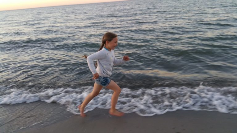 IMG-20220802-WA0003 – Hubertus Boltenhagen A child runs along the beach by the sea at sunset.